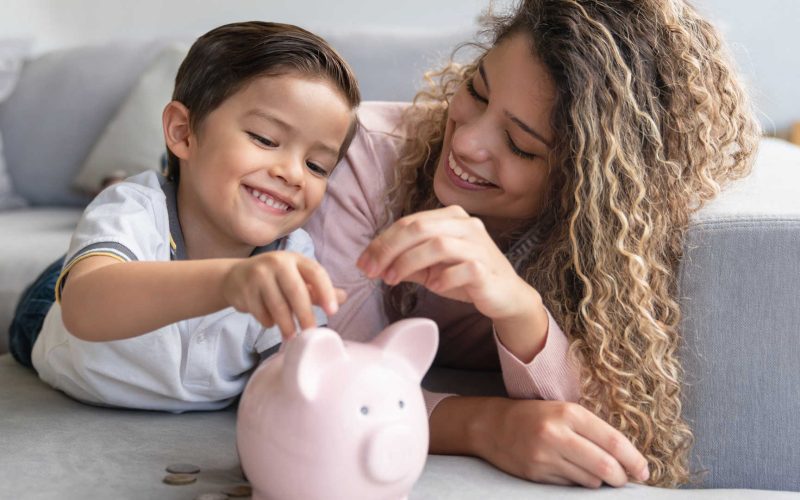 Mother and son saving money in a piggybank