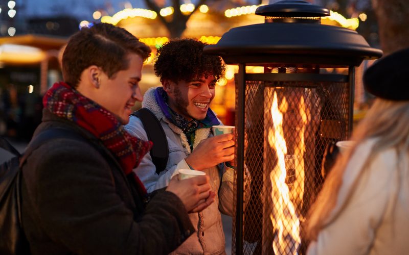 Friends Gathered Around Outdoor Heater