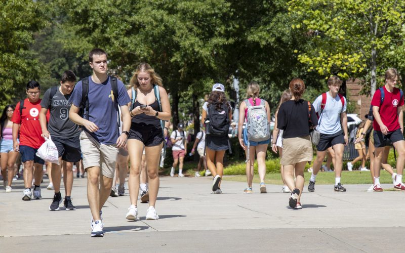 Students walking outside on a bright sunny day on campus