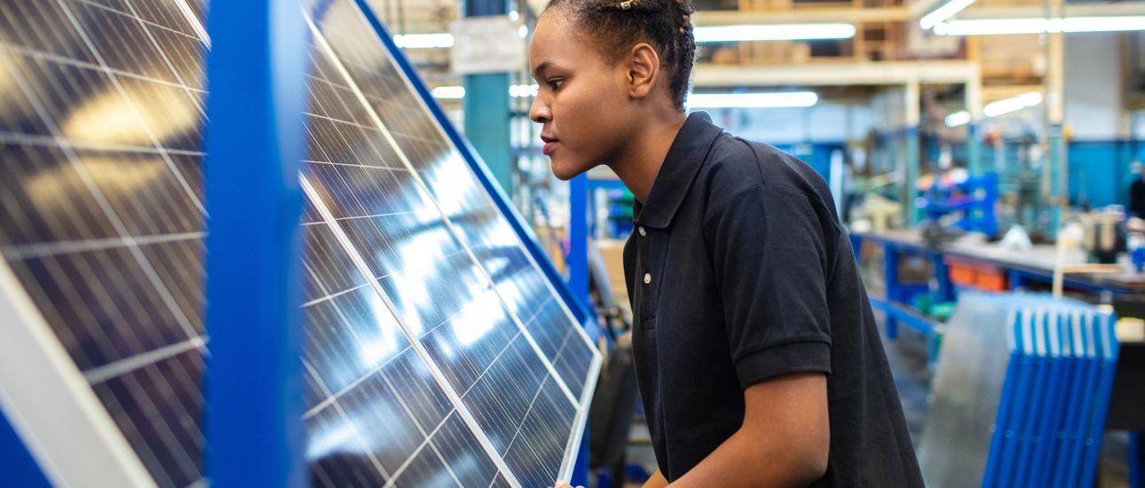 Quality engineer examining solar panels in factory