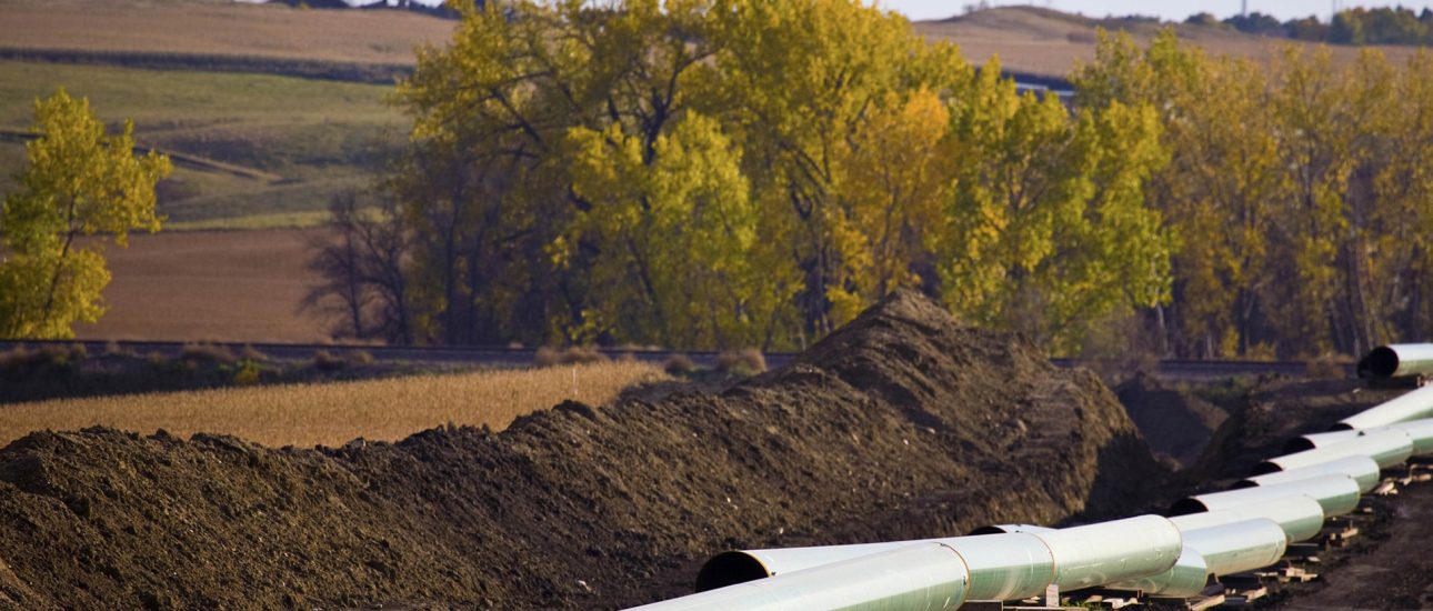 Pipeline construction with wind turbines in the background