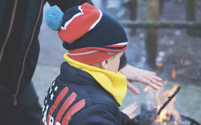 Child outside with campfire